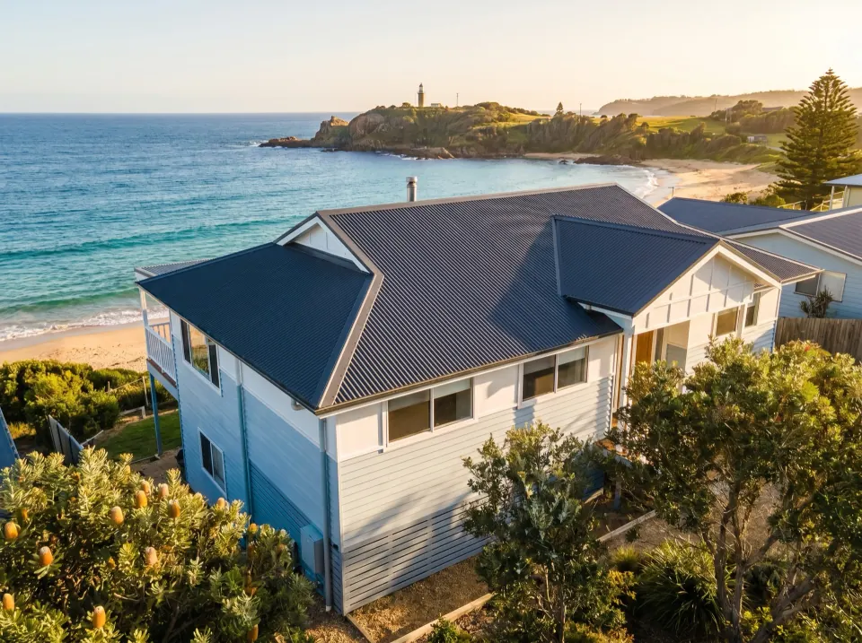 Newly re-roofed weatherboard coastal home on the Sapphire Coast with charcoal Colorbond sheets and crisp white gutters